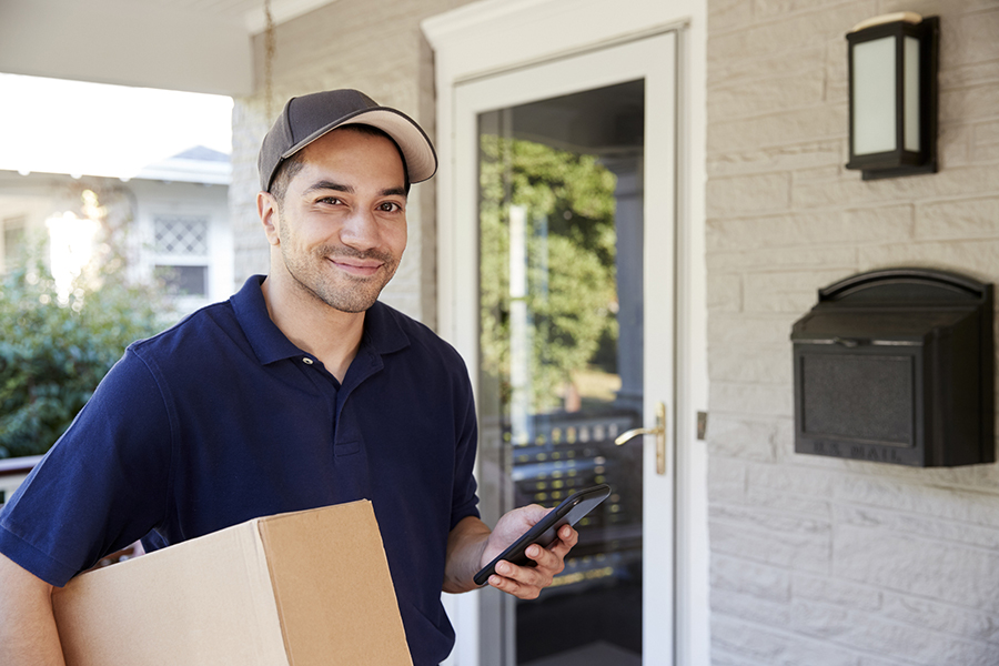 Portrait Of Courier With Digital Tablet Delivering Package